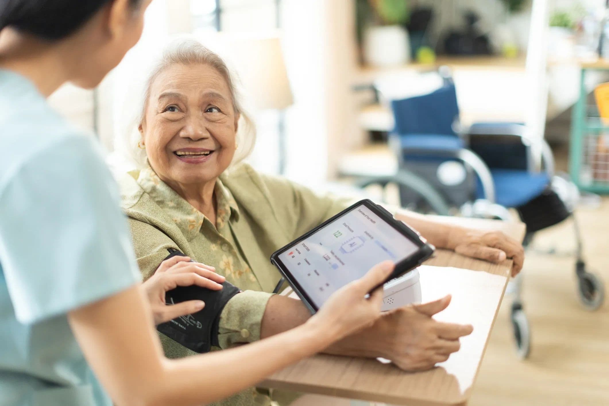 Home care nurse checking an older woman's blood pressure at home